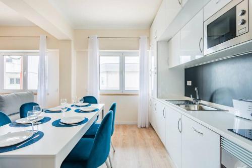 a kitchen with a white table and chairs and a kitchen with a sink at A Coastal Retreat in Oeiras in Paço de Arcos