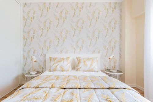 a bedroom with a white bed with two tables at A Coastal Retreat in Oeiras in Paço de Arcos