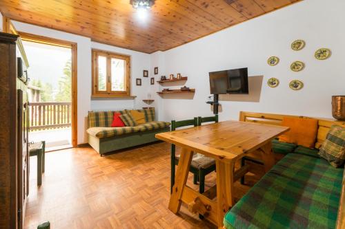 a living room with a wooden table and a couch at Chez Umbus, centrale e immerso nel verde, grande terrazzo in Champoluc