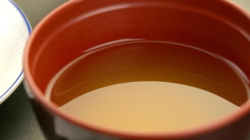 a red cup filled with milk on a table at Yufuin Yamaboushi in Yufuin