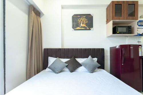 a bedroom with a bed with white sheets and pillows at Cozy Studio Apartment in Jagatpura - Luxacaves Eco in Siroli