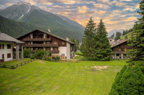 a large grassy yard in front of a mountain at Chez Umbus, centrale e immerso nel verde, grande terrazzo in Champoluc