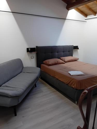 a bedroom with a bed and a couch at HOUSE Sant'Angelo in Acquapendente