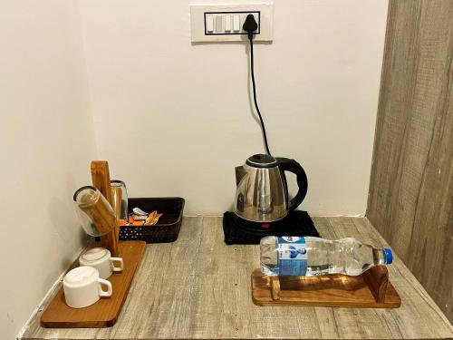 a table with a tea kettle and a bottle on the floor at Grand Narmada Jungle Homestay Resort-Bandhavgarh in Tāla