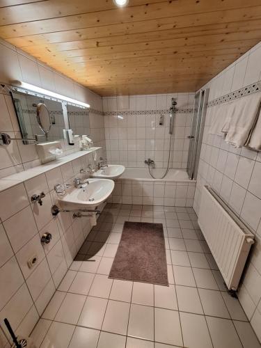a bathroom with two sinks and a shower and a tub at Romantikhus in Brand