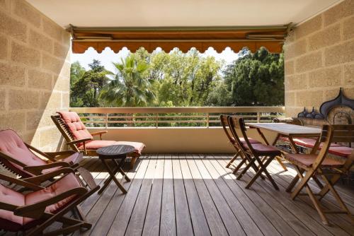 un balcon avec une table et des chaises et une grande fenêtre dans l'établissement Suite Jam - Superbe Appartement à Cannes, à Cannes