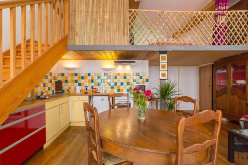 une cuisine et une salle à manger avec une table en bois et des chaises dans l'établissement beau canut à côté du gros cailloux, à Lyon