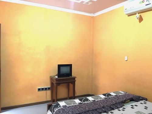 a room with a bed and a tv on a table at Hotel Alami near Alun-Alun Klaten in Klaten