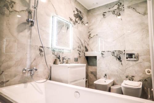 a bathroom with a tub and a toilet and a sink at Oasis Karpat in Polyana