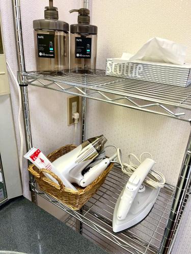 a wire shelf with some hair brushes in it at I Love Izu in Futo