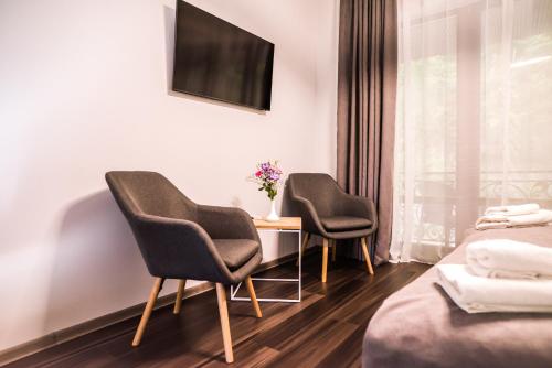 two chairs and a table in a hotel room at Oasis Karpat in Polyana
