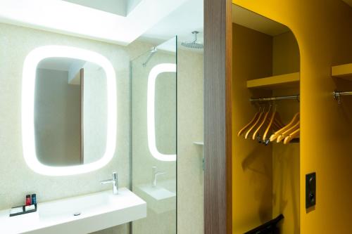 a bathroom with a sink and a mirror at Oceania Paris Porte De Versailles in Paris