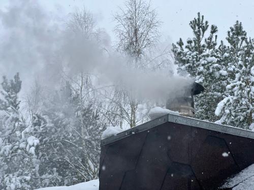 a smoke stack on top of a house in the snow at U Progu Lasu in Budy