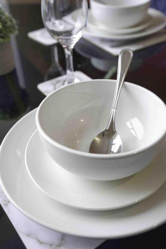 a spoon in a white bowl on a plate at Dalviat Getaway in Balloch