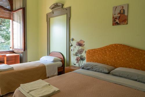 a room with two beds and a mirror at Villa San Giuseppe in Brescia
