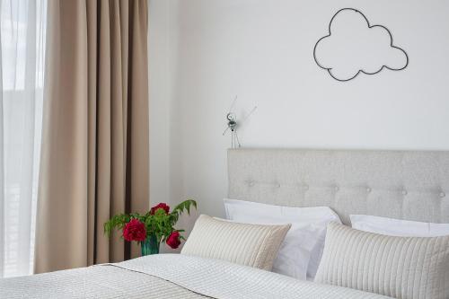 a bedroom with a bed with a cloud on the wall at Holečkova Apartments in Prague