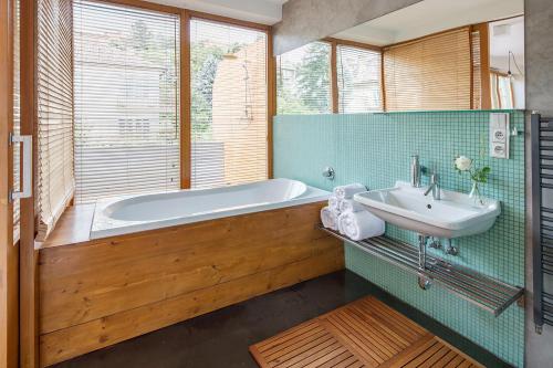 a bathroom with a tub and a sink at Holečkova Apartments in Prague