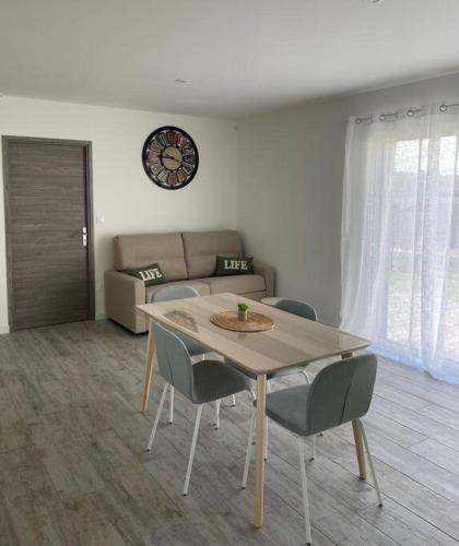 un salon avec une table, des chaises et un canapé dans l'établissement Maison Les Lauriers, à Le Val