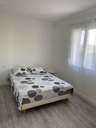 une chambre avec un lit avec une couette noire et blanche dans l'établissement Maison Les Lauriers, à Le Val