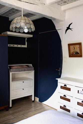 a bedroom with a blue wall with a bed and a desk at Si Long va bien in Long