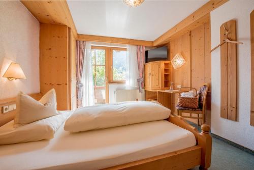 a bedroom with two beds in front of a window at Landhotel Älpili in Gaschurn