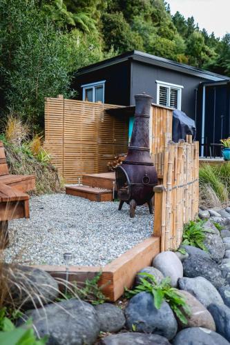 a backyard with a fire pit and a fence at Kaitake Kabana - Unique, off-grid, studio retreat in Oakura