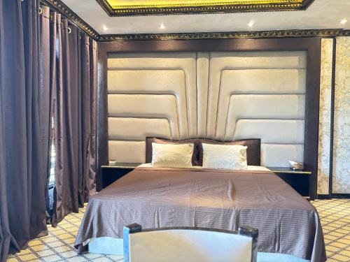 a bedroom with a large bed with a large headboard at Yuki Grand Hotel in Athurugiriya