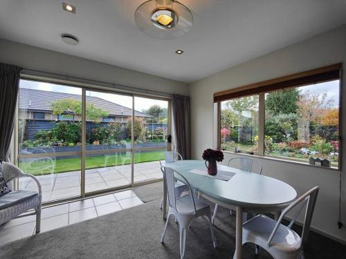 a dining room with a table and chairs and windows at Quiet in the Court in Lorneville