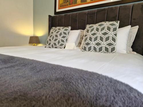 a bedroom with a bed with pillows at B&B on Buckingham Guest House in Johannesburg