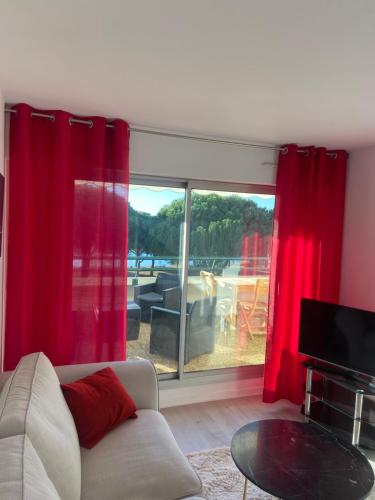 - un salon avec des rideaux rouges et un canapé dans l'établissement Très beau 2 pièces dans résidence de standing, à La Grande Motte
