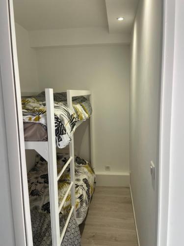 Cette petite chambre dispose de lits superposés et d'une échelle menant à un lit superposé. dans l'établissement Très beau 2 pièces dans résidence de standing, à La Grande Motte