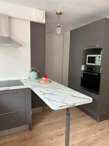 - une cuisine avec une table et un gâteau dans l'établissement Appartement pour 2, à Le Blanc