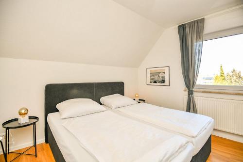 a bedroom with a large bed and a window at Haus Kehrwieder Leuchtturm in Grömitz