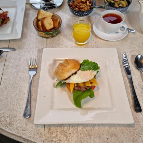 a sandwich on a white plate on a table at B&B on Buckingham Guest House in Johannesburg