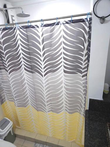 a shower curtain in a bathroom with a toilet at lea home flair tower staycation mandaluyong in Manila