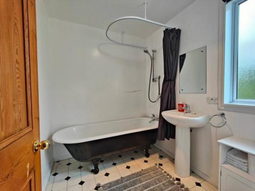a bathroom with a bath tub and a sink at Villa Vista in Riverton