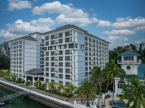 a large white building next to a river at Seaview Suites at Admiral Bay in Port Dickson