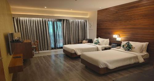 a hotel room with two beds and a television at The Golkonda Resort and Spa in Hyderabad
