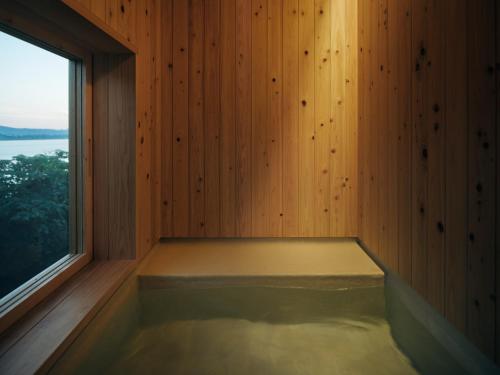a sauna with a window in a wooden wall at YAWN YARD Kouri Island in Kouri