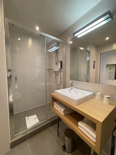 a bathroom with a sink and a shower at Kyriad Paris 18 - Porte de Clignancourt - Montmartre in Paris