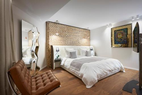 a bedroom with a large bed and a chair at First Croisette in Cannes