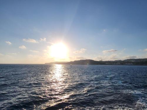 a sun setting over a large body of water at Roma Hotel in Sliema