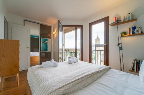 - une chambre avec un grand lit blanc et un balcon dans l'établissement Blue Light - Appt pour 4p Paris, à Paris