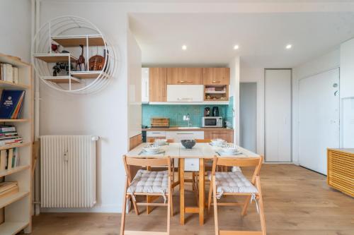 une cuisine avec une table et des chaises dans une pièce dans l'établissement Blue Light - Appt pour 4p Paris, à Paris