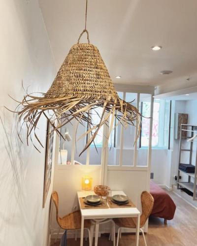 Cette chambre comprend une table et un grand lustre. dans l'établissement Le studio du Marché, hyper centre, à La Rochelle