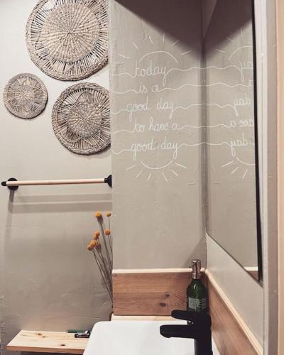 une salle de bains avec un mur recouvert d'écriture. dans l'établissement Le studio du Marché, hyper centre, à La Rochelle