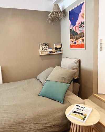 - une petite chambre avec un lit et une table dans l'établissement Le studio du Marché, hyper centre, à La Rochelle