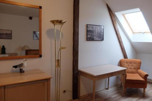 Zimmer mit einem Tisch, einer Lampe und einem Stuhl in der Unterkunft Pension Domke in Ahlbeck