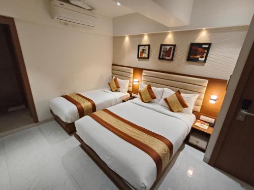 a hotel room with two beds in a room at Hotel Pearl Residency Thane in Thane
