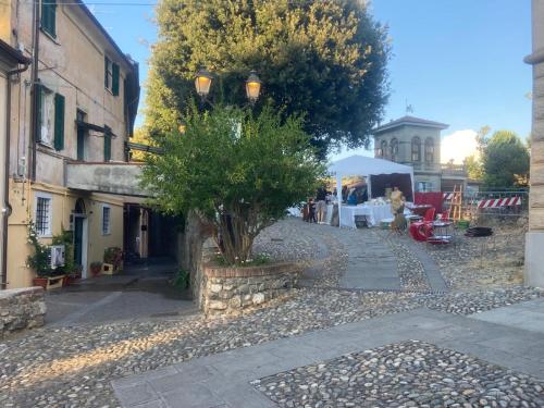 a street in a town with a tree and a tent at Torrione Stella Rooms in Sarzana